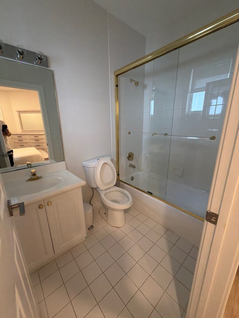 Small bathroom remodel with white tile, glass shower enclosure, and vanity in Palm Beach County